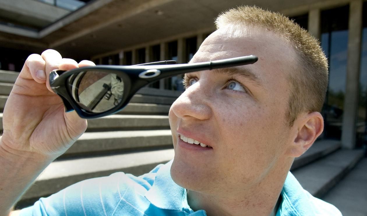 Man putting on glasses