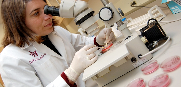 RPB Researcher looking through microscope